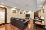 This stunning living space boasts a modern design with a comfortable leather sofa and a sleek entertainment center.