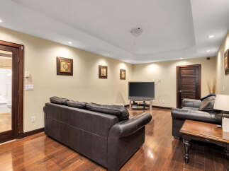 This stunning living space boasts a modern design with a comfortable leather sofa and a sleek entertainment center.