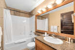 Step into this inviting bathroom, featuring a pristine white bathtub and a stylish vanity with a granite countertop.