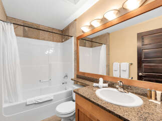 Step into this inviting bathroom, featuring a pristine white bathtub and a stylish vanity with a granite countertop.
