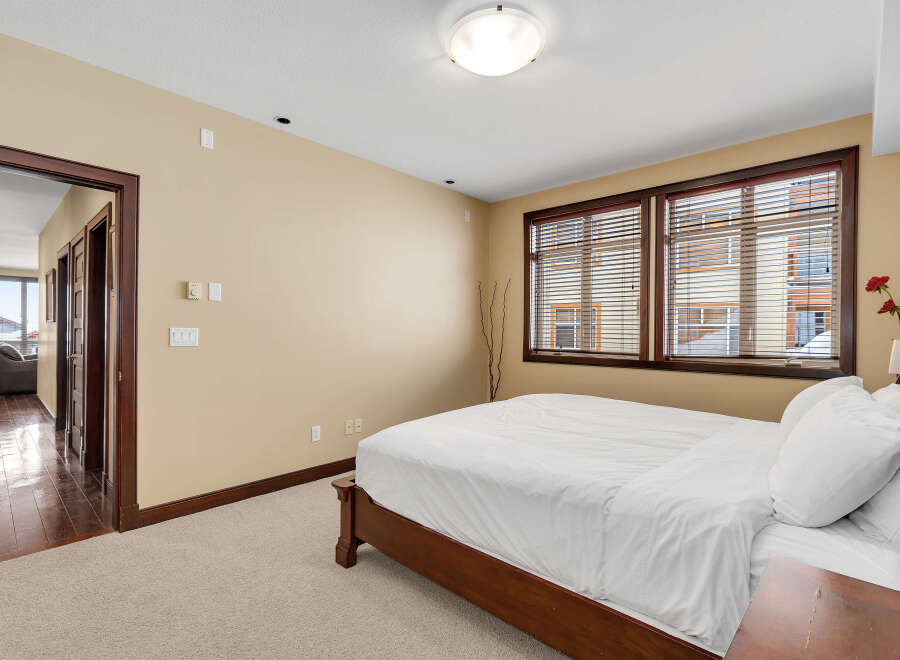 This inviting bedroom features a comfortable bed with crisp white linens, creating a serene and relaxing atmosphere.