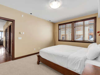 This inviting bedroom features a comfortable bed with crisp white linens, creating a serene and relaxing atmosphere.