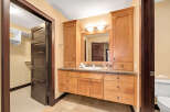 This stunning bathroom boasts custom cabinetry and a granite countertop, offering both style and functionality.