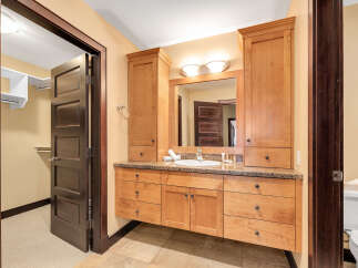 This stunning bathroom boasts custom cabinetry and a granite countertop, offering both style and functionality.