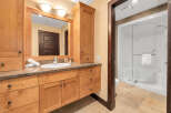 This stunning bathroom boasts a beautiful wooden vanity with ample storage, complemented by a granite countertop.