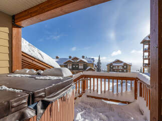 Enjoy the winter wonderland from this stunning property! This home features a cozy hot tub, perfect for relaxing after a day on the slopes.