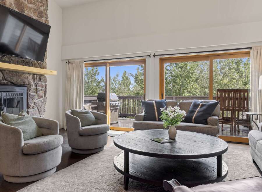This stunning living room boasts a cozy fireplace and a large flat-screen TV, perfect for relaxing evenings.