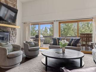 This stunning living room boasts a cozy fireplace and a large flat-screen TV, perfect for relaxing evenings.