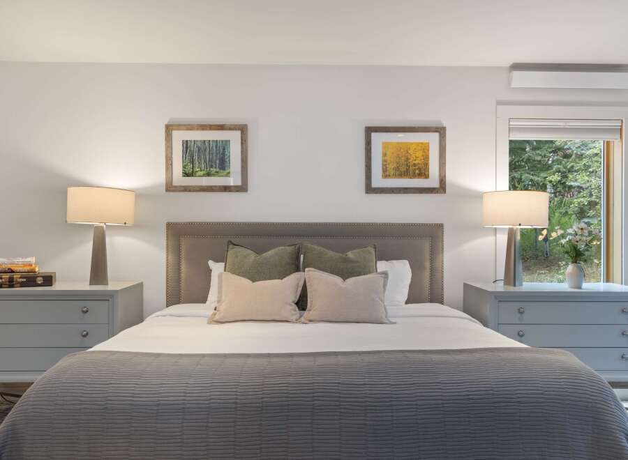 This inviting bedroom offers a serene retreat with its neutral color palette and cozy ambiance.