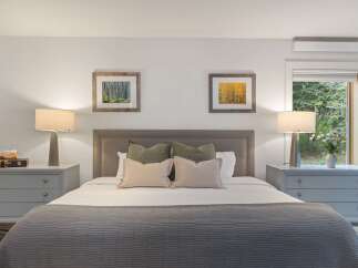 This inviting bedroom offers a serene retreat with its neutral color palette and cozy ambiance.