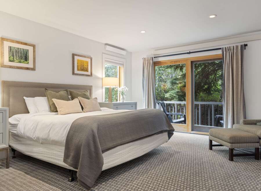 Step into this serene bedroom, featuring a plush bed and a cozy seating area.