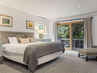 Step into this serene bedroom, featuring a plush bed and a cozy seating area.