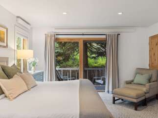 Step into a serene bedroom retreat, where natural light floods through the expansive glass doors leading to a private balcony.