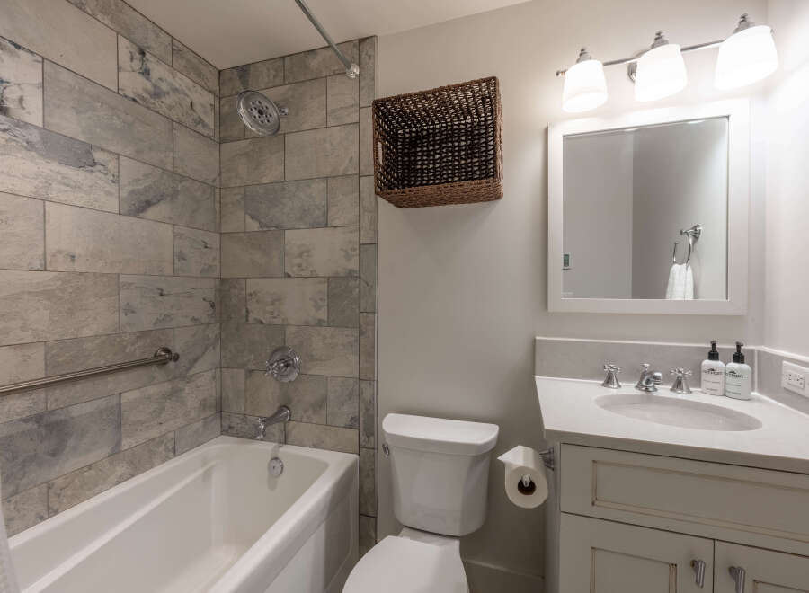 This stunning bathroom features a modern design with elegant tile work and a luxurious soaking tub.