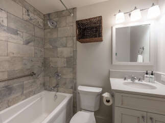 This stunning bathroom features a modern design with elegant tile work and a luxurious soaking tub.