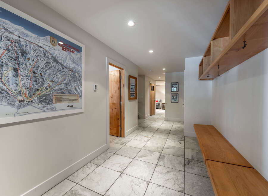 Step into this inviting entryway, featuring a stylish ski resort map and a convenient wooden bench.