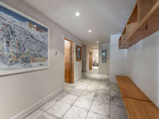Step into this inviting entryway, featuring a stylish ski resort map and a convenient wooden bench.