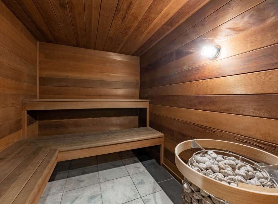 Step into relaxation with this stunning sauna, featuring beautiful wooden paneling and a cozy bench.