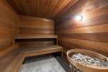 Step into relaxation with this stunning sauna, featuring beautiful wooden paneling and a cozy bench.