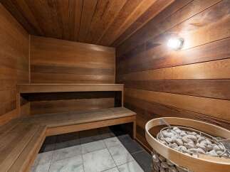 Step into relaxation with this stunning sauna, featuring beautiful wooden paneling and a cozy bench.