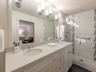 This luxurious bathroom features a double vanity with ample counter space and elegant fixtures.