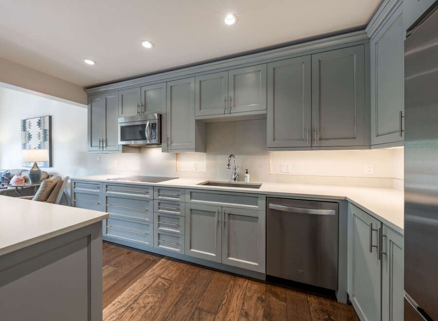 This stunning kitchen boasts modern design with sleek gray cabinetry and stainless steel appliances, creating a stylish and functional space.