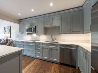 This stunning kitchen boasts modern design with sleek gray cabinetry and stainless steel appliances, creating a stylish and functional space.