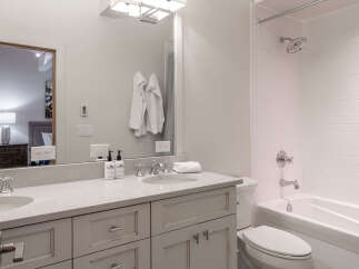 Step into a beautifully designed bathroom featuring a sleek vanity with ample storage and a pristine countertop.