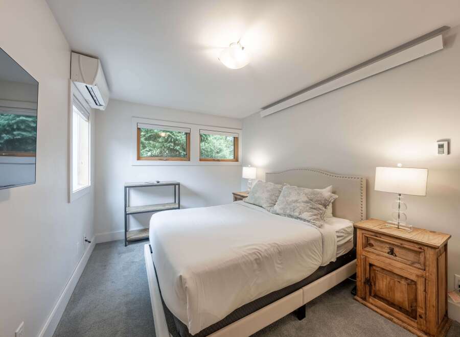 This inviting bedroom offers a serene retreat with its neutral color palette and ample natural light.