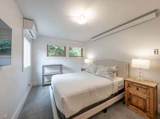 This inviting bedroom offers a serene retreat with its neutral color palette and ample natural light.