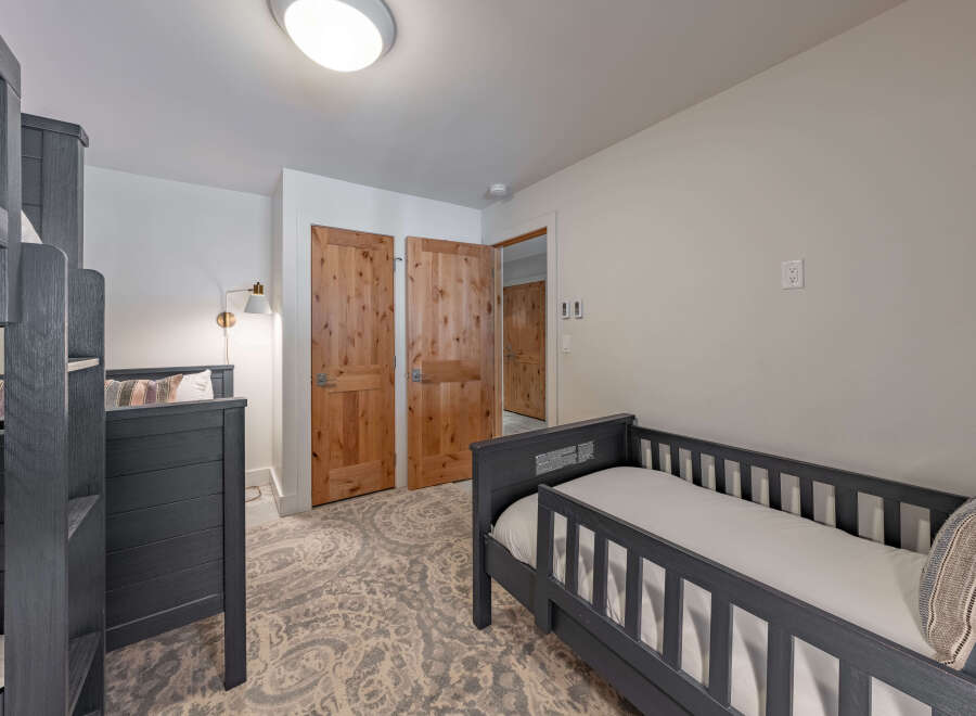 This cozy bedroom features a bunk bed and a toddler bed, perfect for a family or guests.