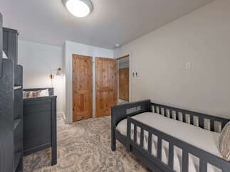 This cozy bedroom features a bunk bed and a toddler bed, perfect for a family or guests.