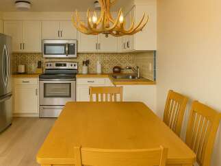This charming kitchen features a unique antler chandelier, adding a touch of rustic elegance to the space.