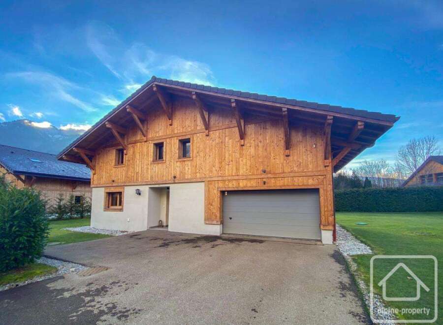 Discover this stunning chalet-style property, boasting a beautiful wooden facade and a modern garage.