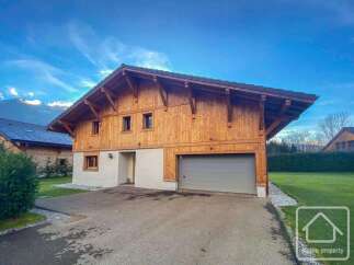 Discover this stunning chalet-style property, boasting a beautiful wooden facade and a modern garage.