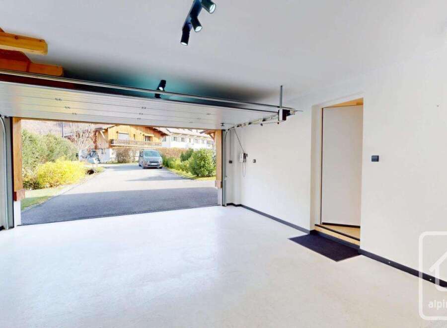 Step into this stunning garage, featuring a sleek, modern design with a pristine white floor.