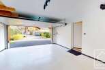 Step into this stunning garage, featuring a sleek, modern design with a pristine white floor.