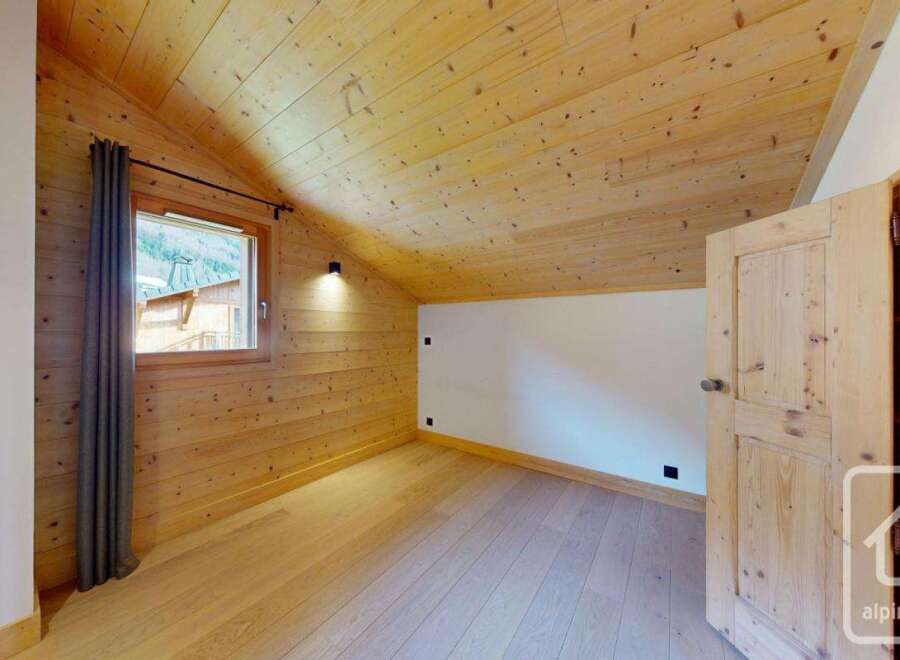 Discover the charm of this cozy room, featuring beautiful wooden walls and ceilings that create a warm and inviting atmosphere.
