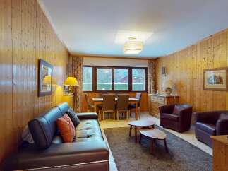This charming property features a cozy living room with a comfortable leather sofa and two armchairs, perfect for relaxing.