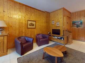 Step into this inviting living space, featuring warm wooden paneling and cozy seating.