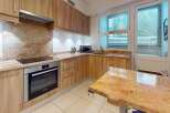 This stunning kitchen boasts a modern design with sleek wooden cabinetry and granite countertops, creating an inviting and functional space.