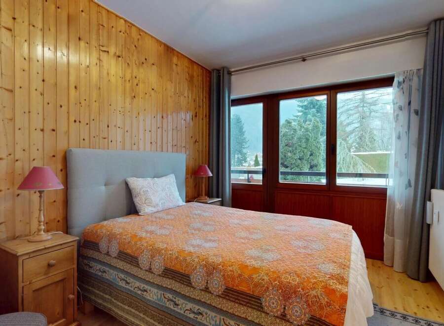 This cozy bedroom features a warm wooden paneling, creating a rustic and inviting atmosphere.