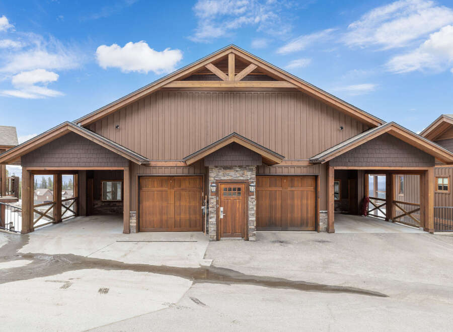 This stunning property boasts a beautiful exterior with a combination of wood and stone accents.