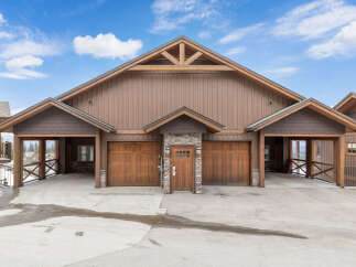 This stunning property boasts a beautiful exterior with a combination of wood and stone accents.