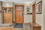 Step into this inviting entryway, showcasing a stunning wooden door and elegant stone flooring.