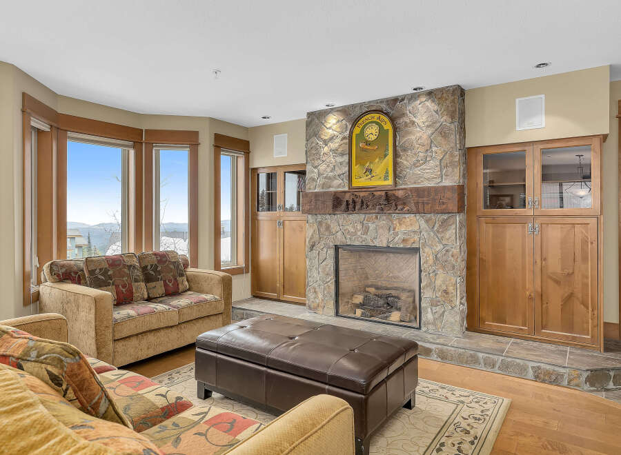 This stunning living room boasts a cozy fireplace with a stone facade, perfect for those chilly evenings.