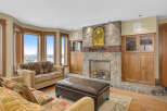 This stunning living room boasts a cozy fireplace with a stone facade, perfect for those chilly evenings.