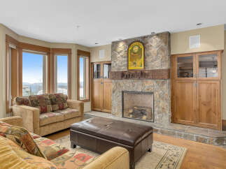 This stunning living room boasts a cozy fireplace with a stone facade, perfect for those chilly evenings.