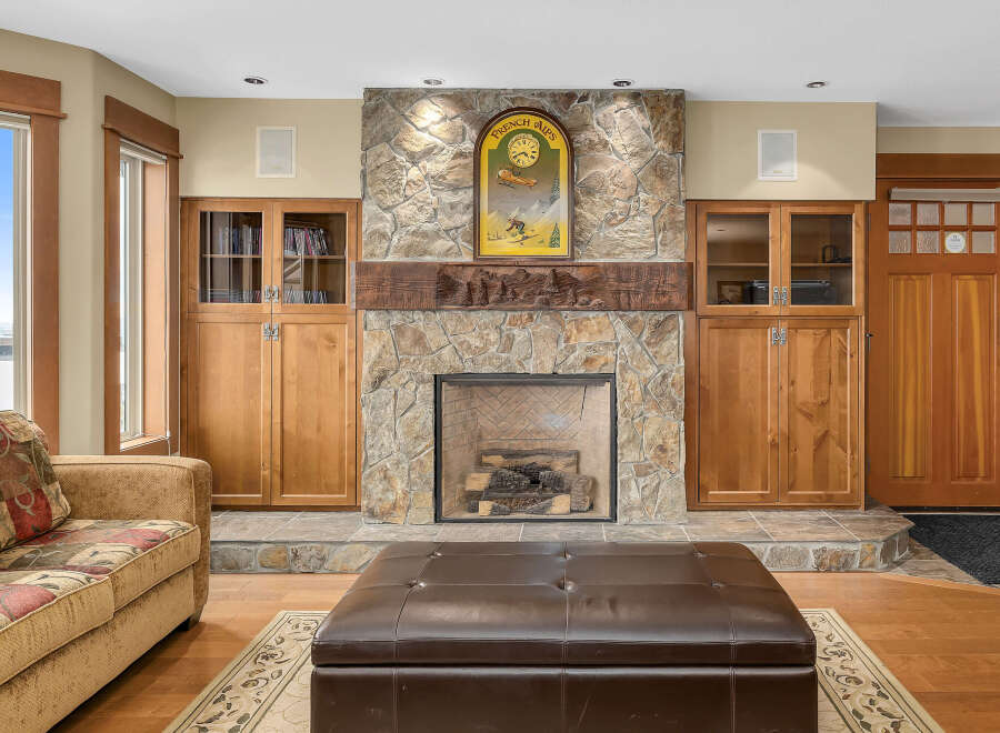 This stunning living room boasts a beautiful stone fireplace, creating a cozy and inviting atmosphere.