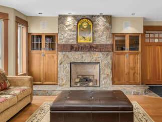 This stunning living room boasts a beautiful stone fireplace, creating a cozy and inviting atmosphere.